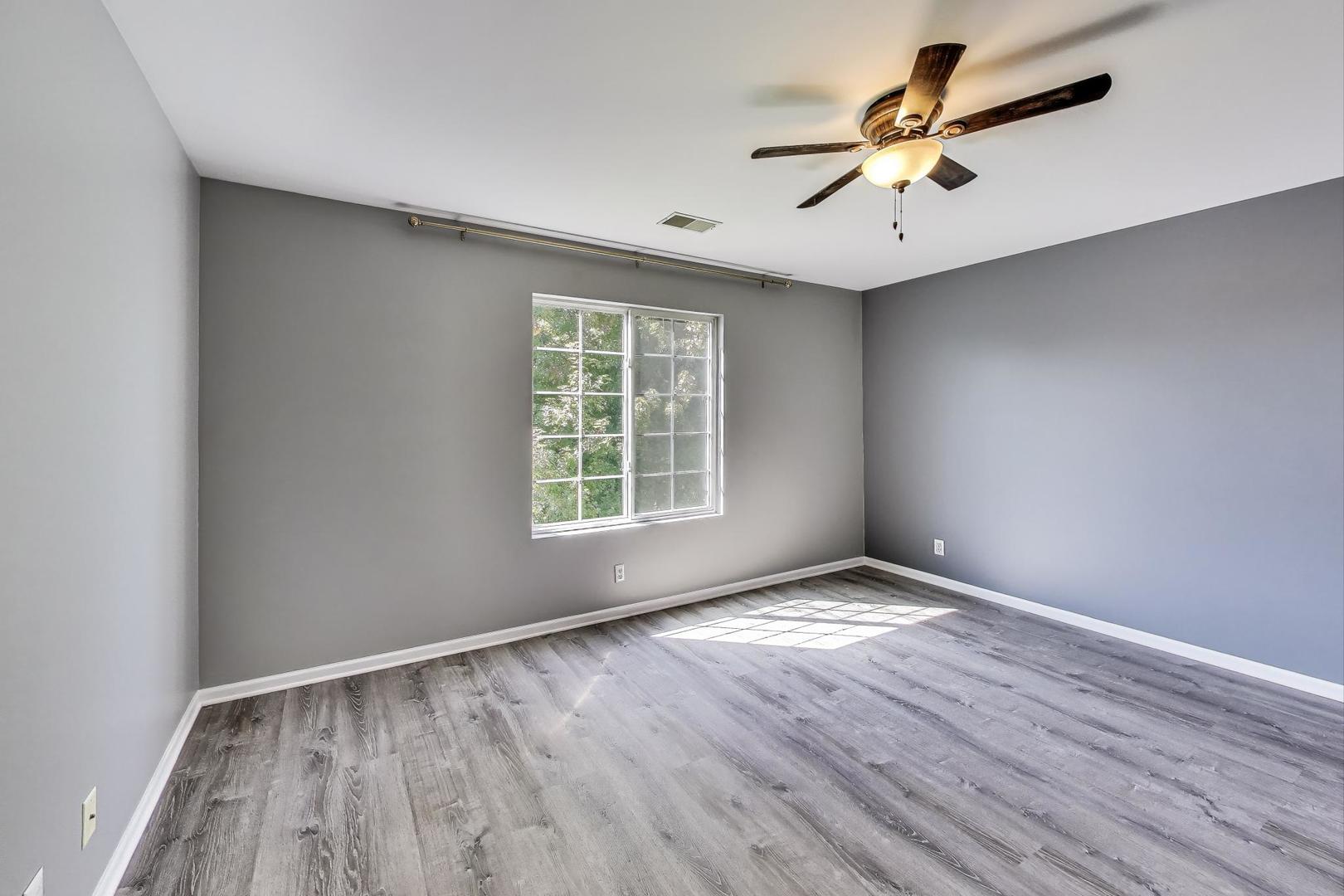 383 Cascade Lane Oswego, IL 60543 - Photo 18 of 35 an empty room with wooden floor fan and windows