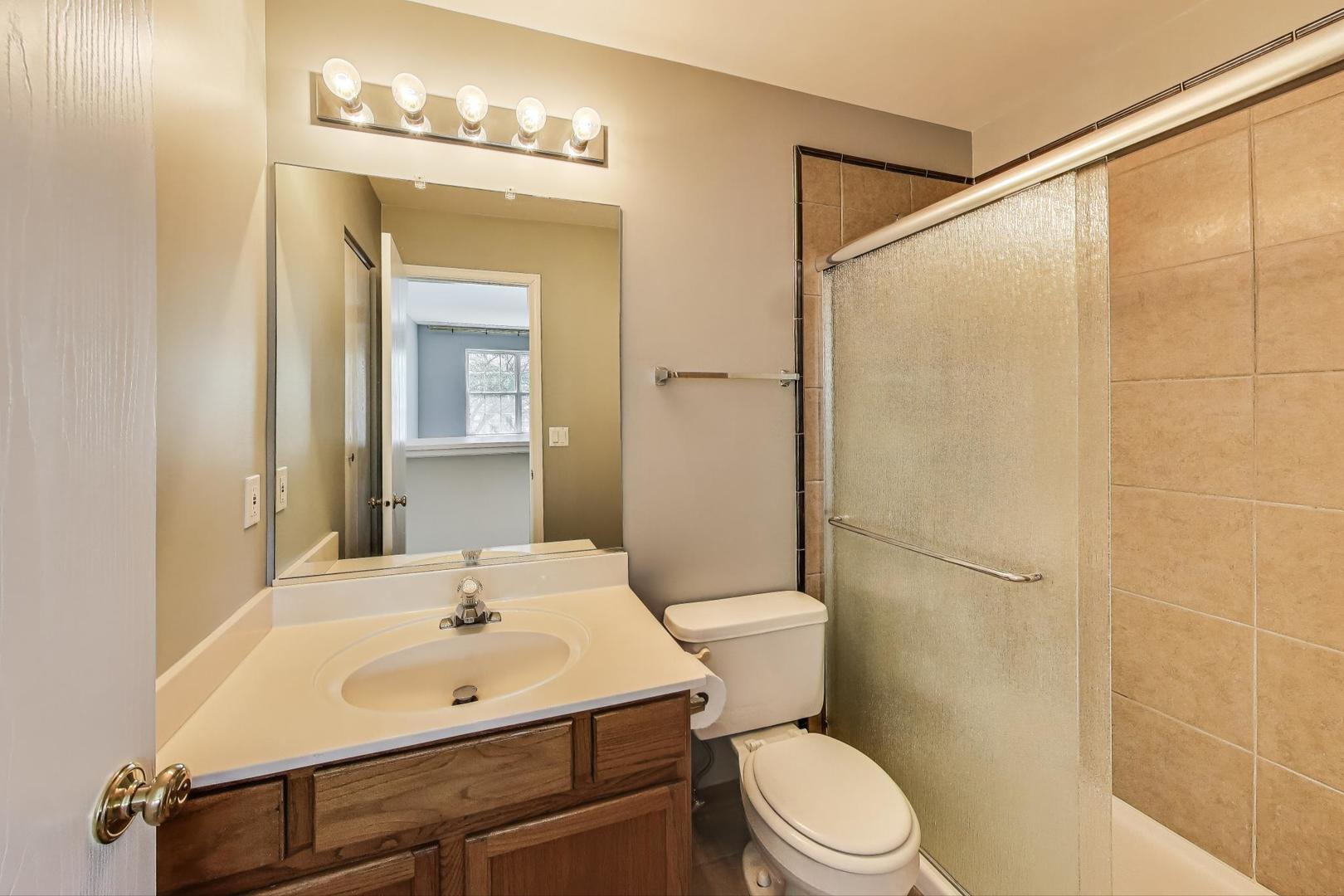 383 Cascade Lane Oswego, IL 60543 - Photo 27 of 35 a bathroom with a sink a toilet and shower