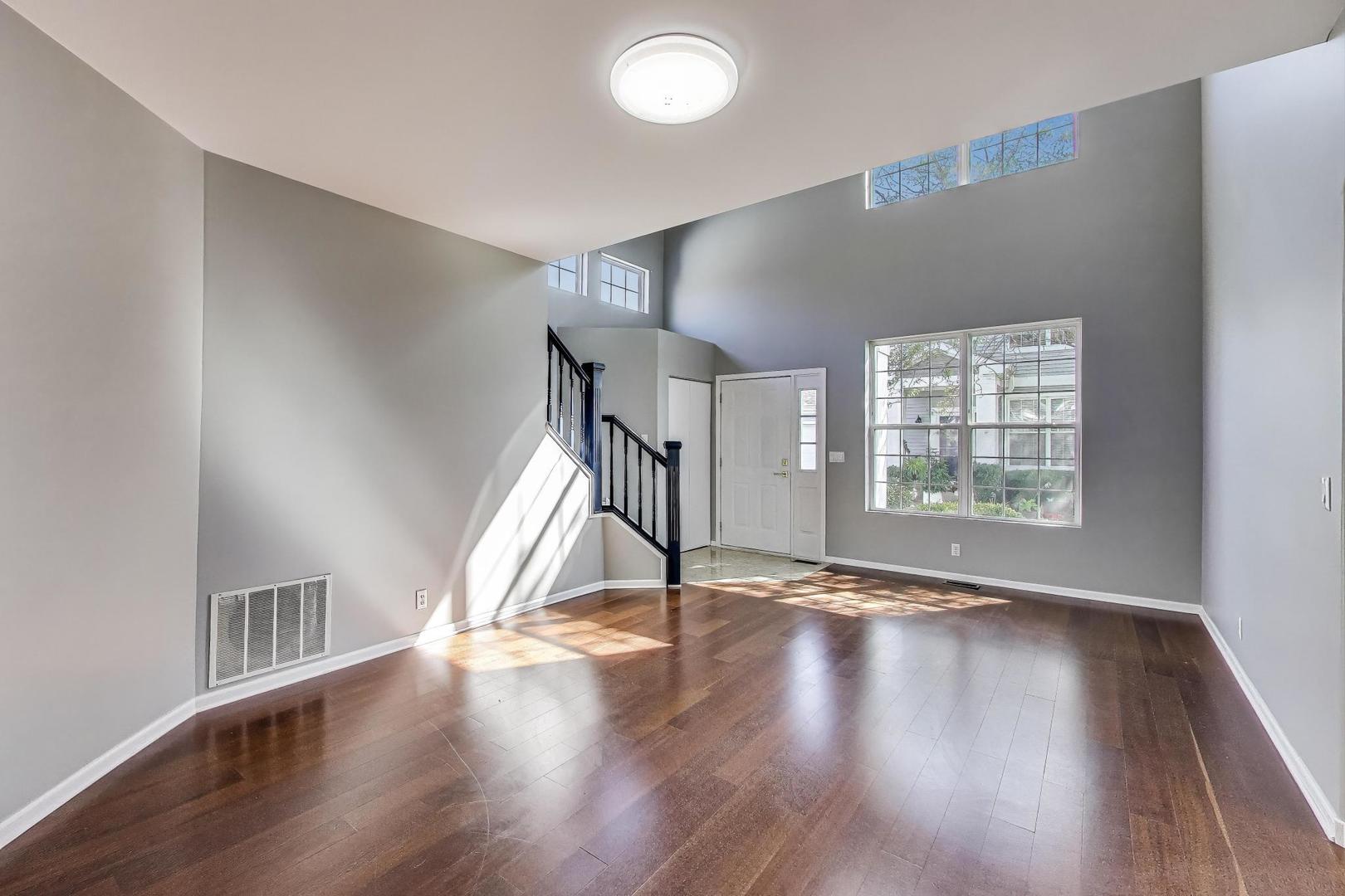 383 Cascade Lane Oswego, IL 60543 - Photo 6 of 35 a view of an empty room with wooden floor and a window
