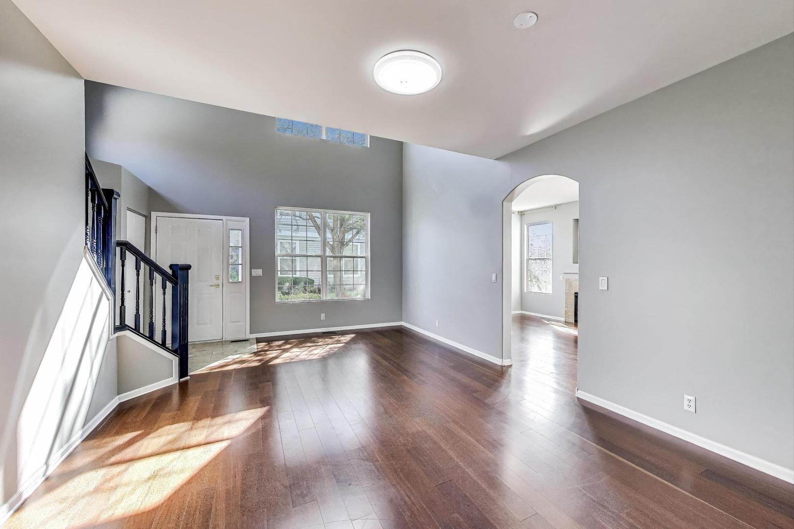 383 Cascade Lane Oswego, IL 60543 - Photo 7 of 35 a view of an empty room with wooden floor and a window