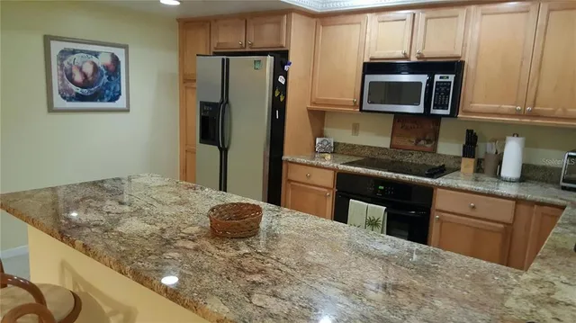 a kitchen with stainless steel appliances granite countertop a sink and a microwave