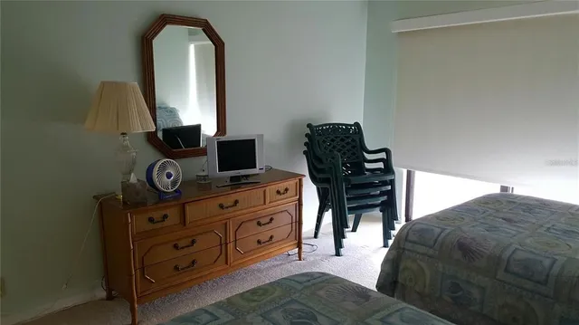 a bed sitting in a bedroom next to a lamp