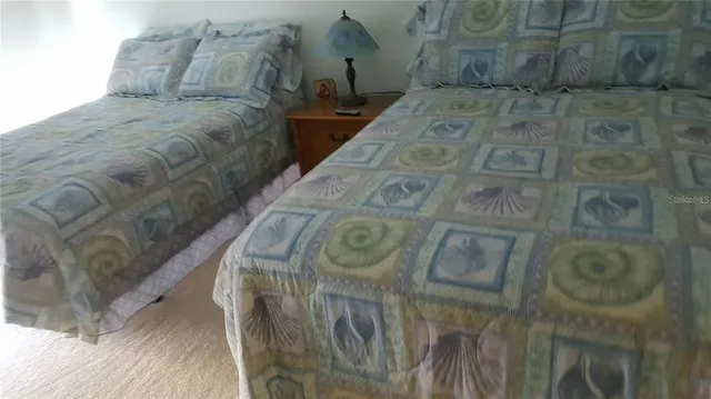 a bedroom with two beds and a large window