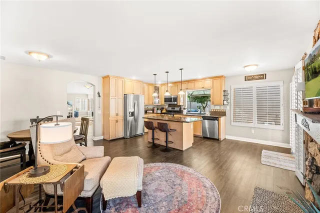 a living room with furniture a large window and wooden floor