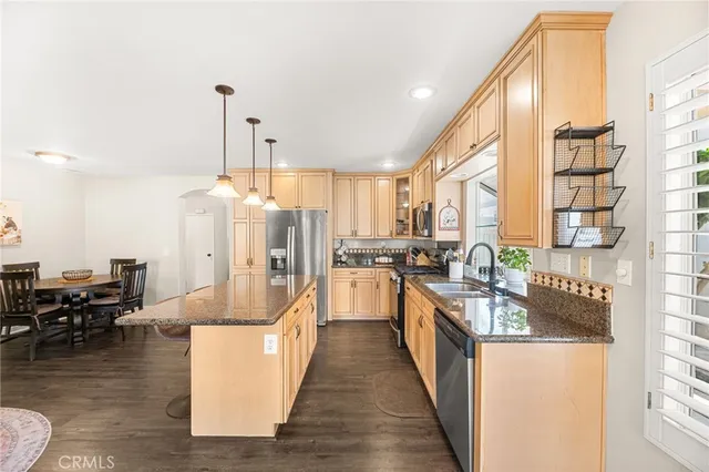 a kitchen with stainless steel appliances granite countertop a stove a sink and a refrigerator