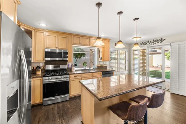 a bathroom with a granite countertop sink and a mirror with toilet