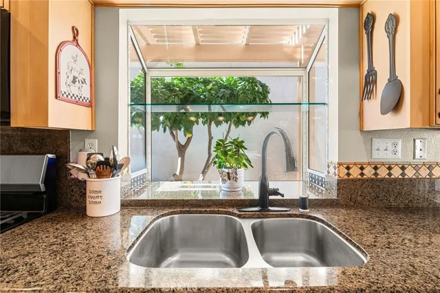 a bedroom with a bed a dresser and a large window