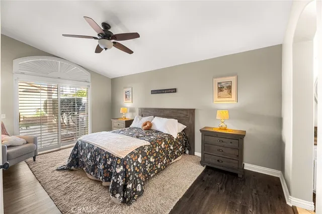 a view of a livingroom with furniture cabinet a ceiling fan and a window