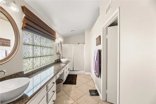 a bathroom with a granite countertop sink mirror vanity and toilet
