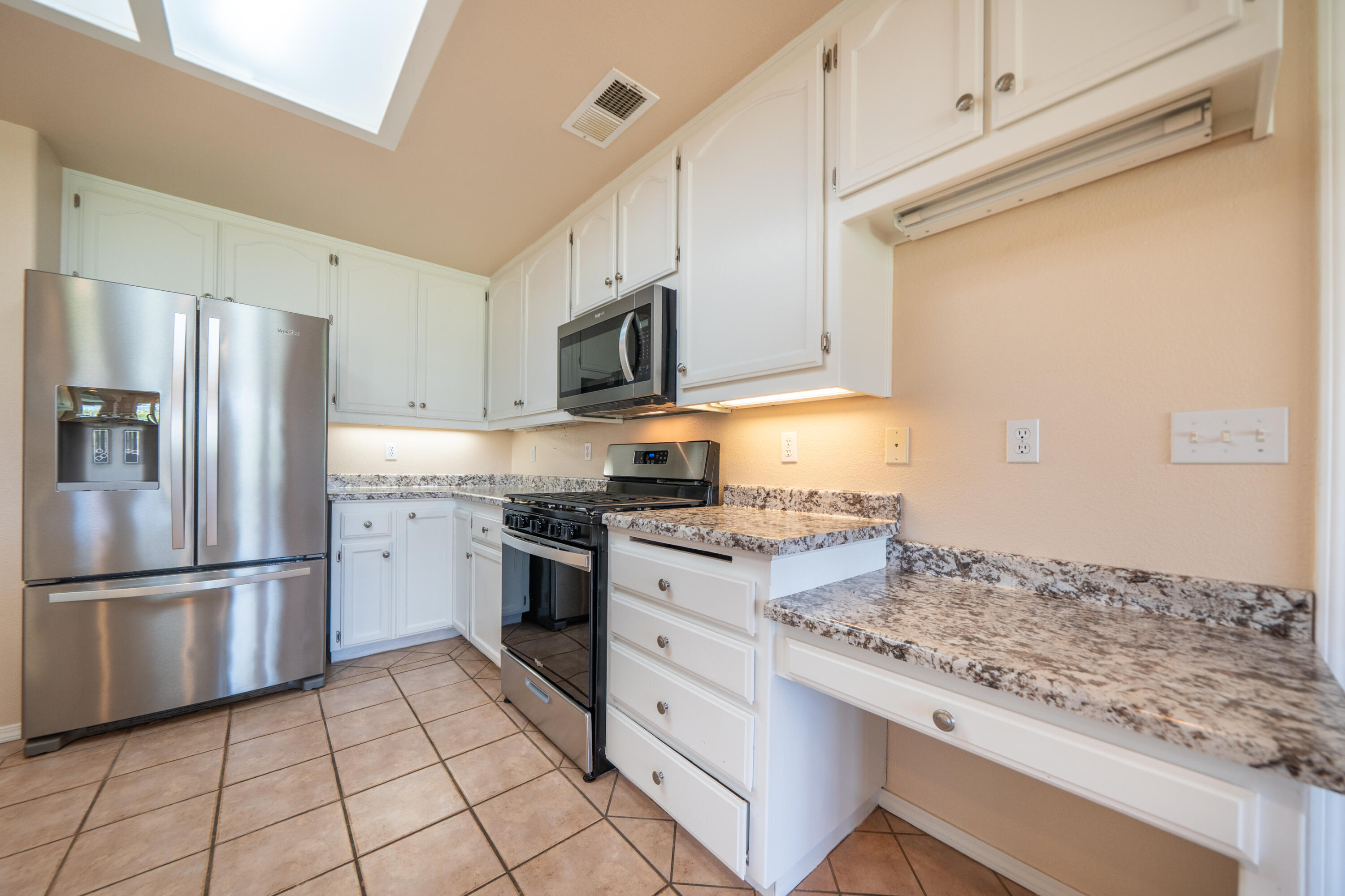 3438 Showboat Court Redding, CA 96003 - Photo 18 of 63 a kitchen with white cabinets and stainless steel appliances