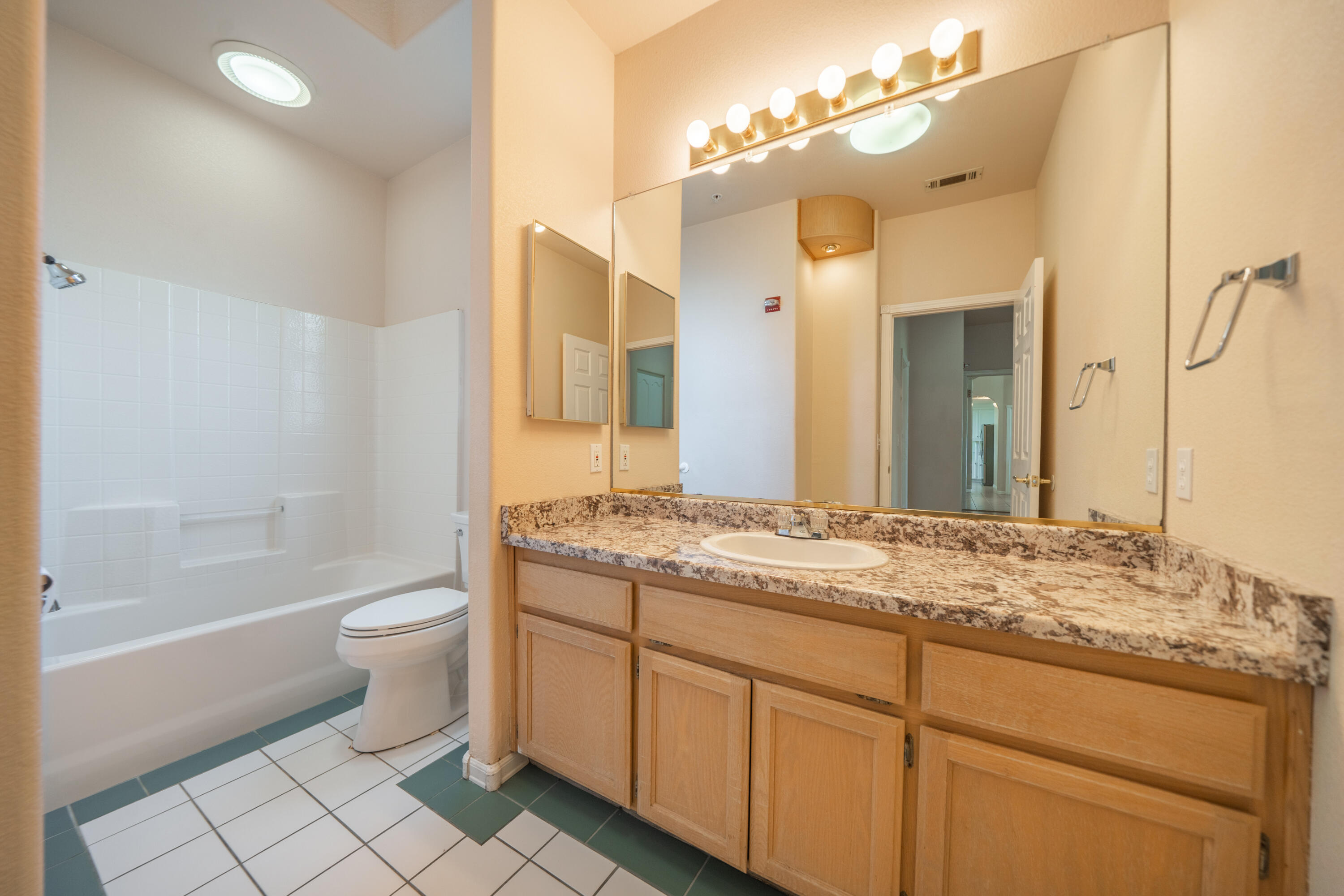 3438 Showboat Court Redding, CA 96003 - Photo 28 of 63 a bathroom with a granite countertop sink toilet a mirror and shower