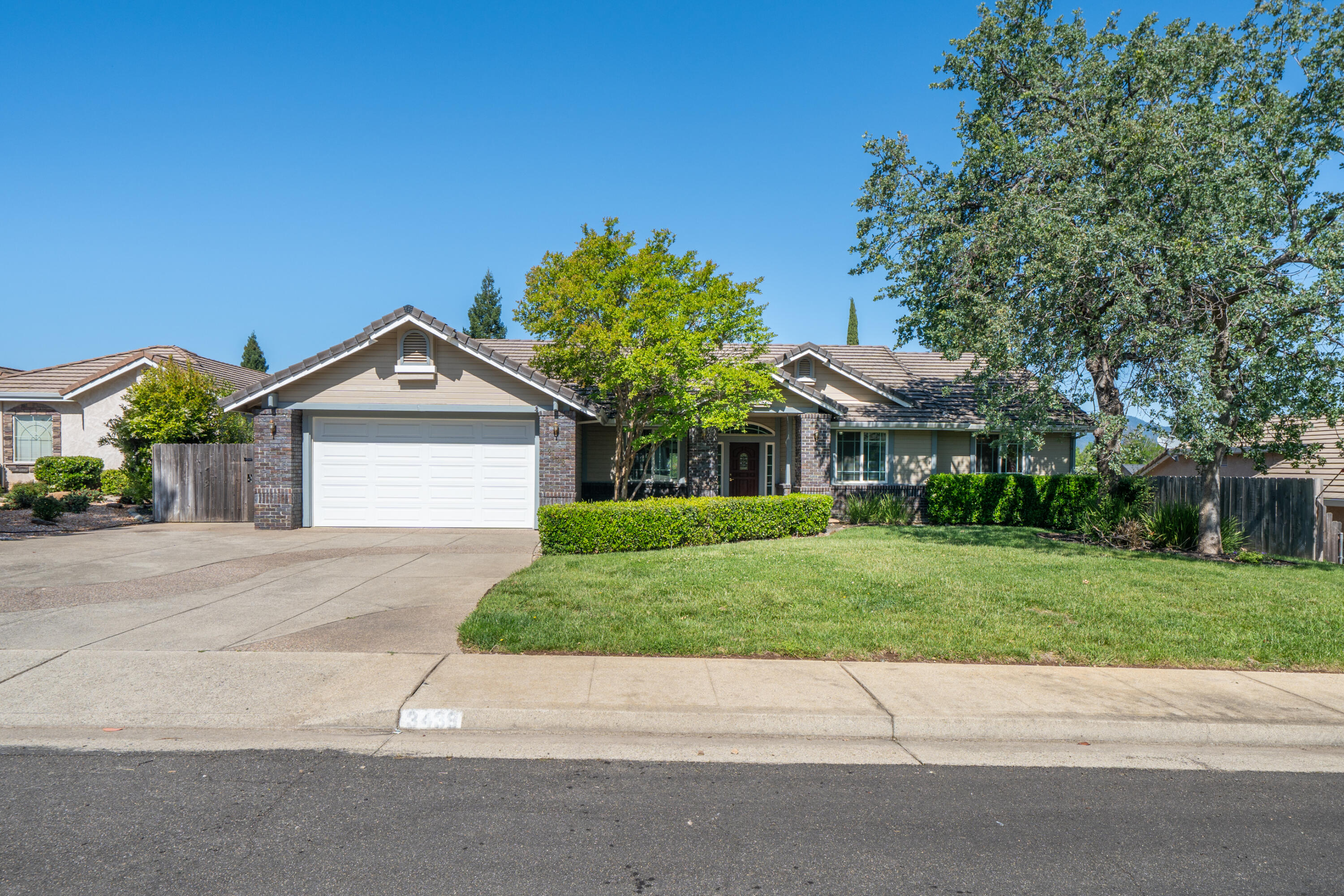 3438 Showboat Court Redding, CA 96003 - Photo 3 of 63 a front view of a house with a yard and garage