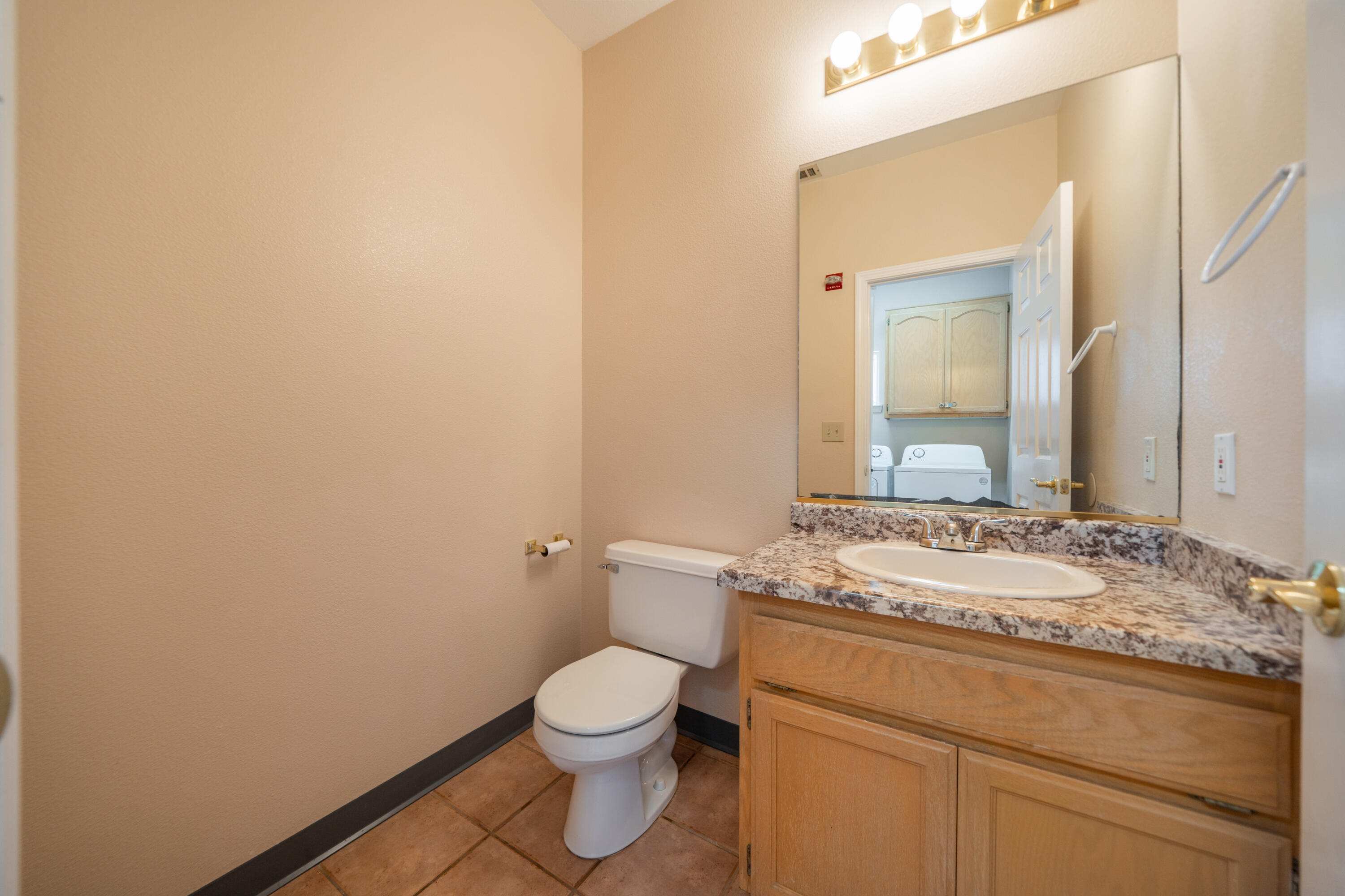 3438 Showboat Court Redding, CA 96003 - Photo 38 of 63 a bathroom with a granite countertop sink a toilet and a mirror