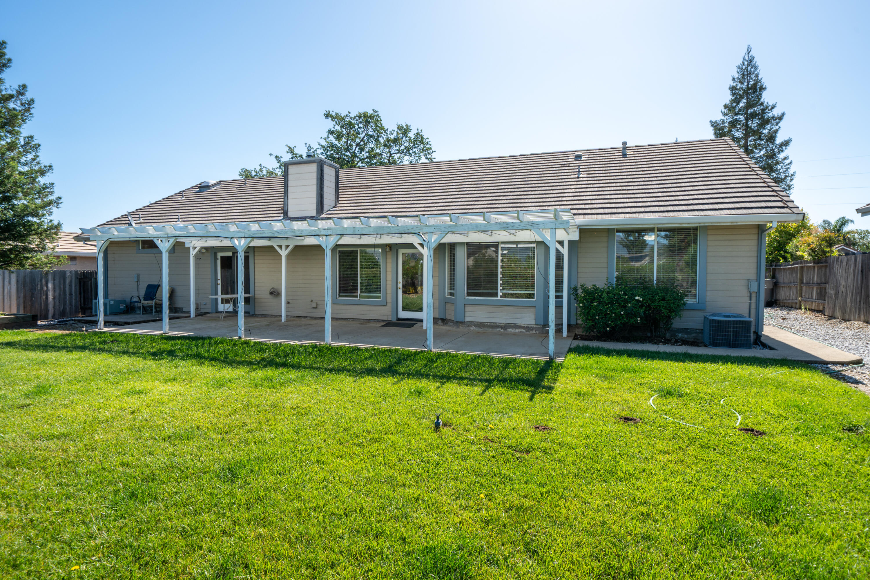 3438 Showboat Court Redding, CA 96003 - Photo 48 of 63 a view of a house with a yard potted plants and a table