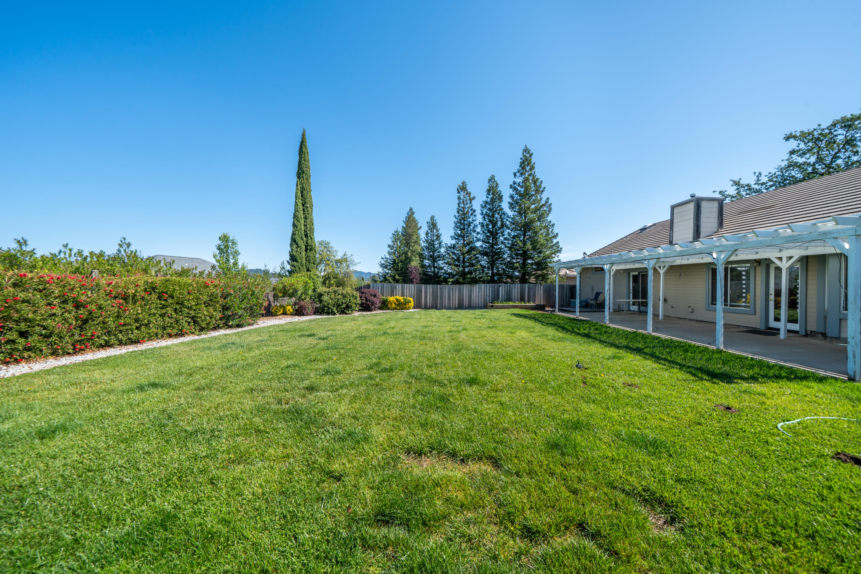 3438 Showboat Court Redding, CA 96003 - Photo 49 of 63 a view of a house with backyard and a tree