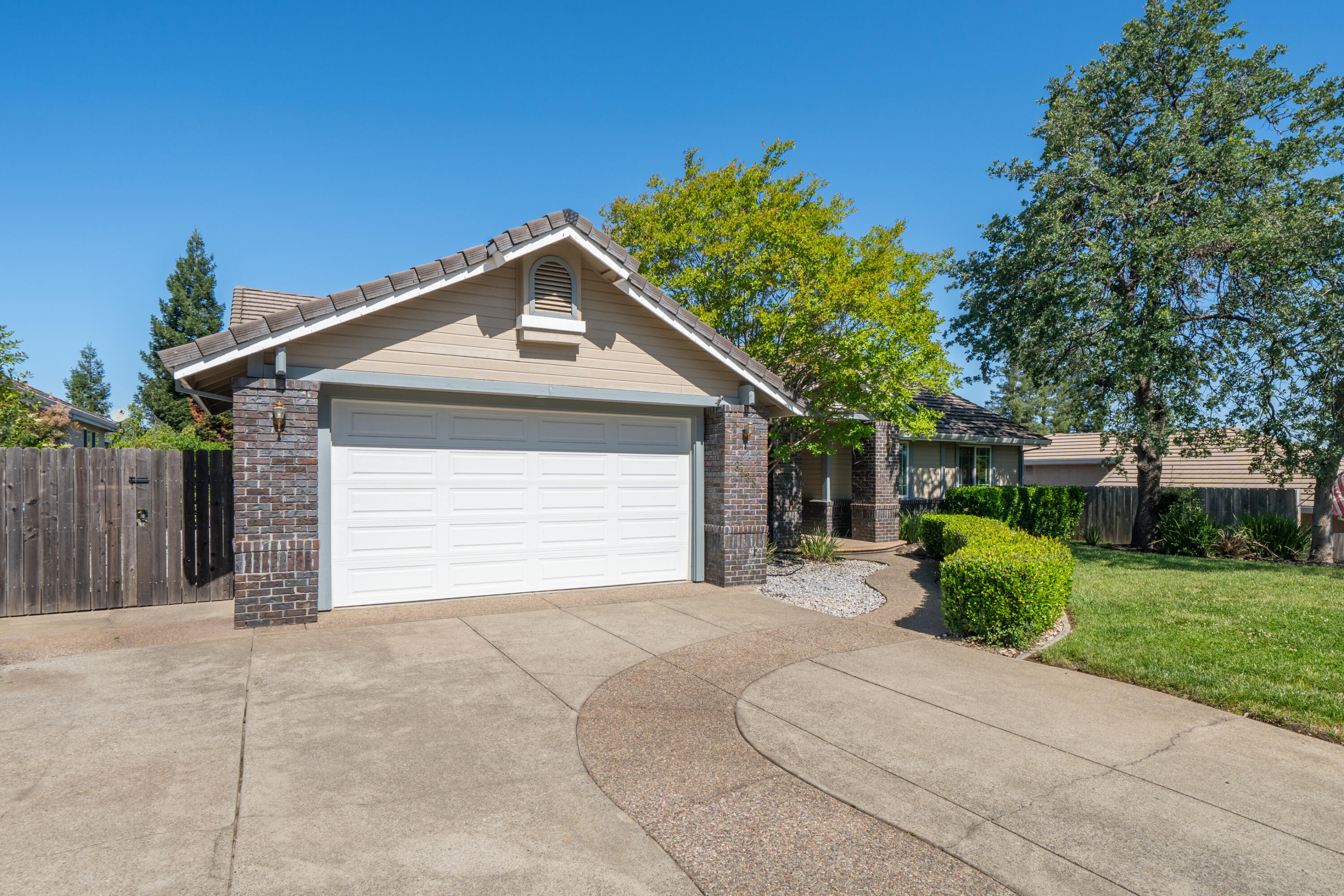 3438 Showboat Court Redding, CA 96003 - Photo 5 of 63 a front view of a house with garage and plants