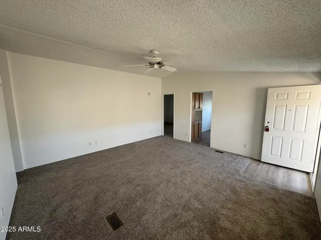 an empty room with windows and fan