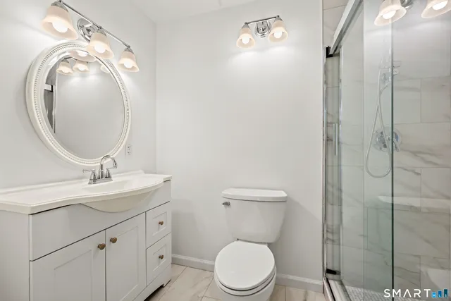 a bathroom with a toilet a sink and mirror