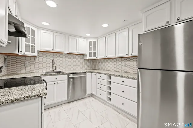 a kitchen with granite countertop cabinets and refrigerator