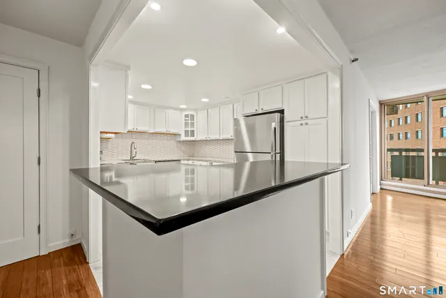 a kitchen with stainless steel appliances granite countertop a sink and a refrigerator