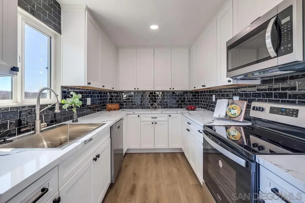 9136 Northcote Road Santee, CA 92071 - Photo 4 of 33 a kitchen with stainless steel appliances granite countertop a stove a sink and a microwave