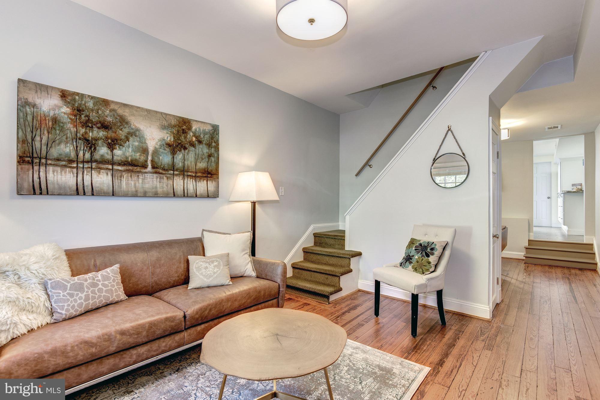 908 Pendleton Street Alexandria, VA 22314 - Photo 4 of 22 a living room with furniture a rug and a wall painting
