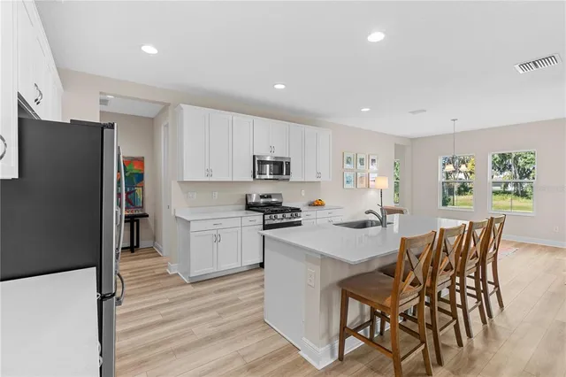 a kitchen that has a lot of cabinets a sink and appliances in it
