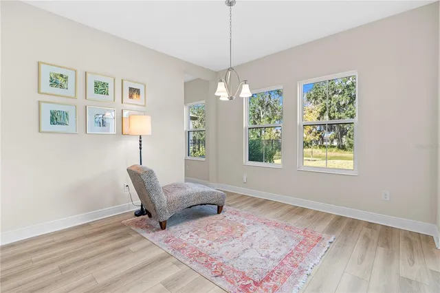 a living room with furniture and painting on the wall with wooden floor