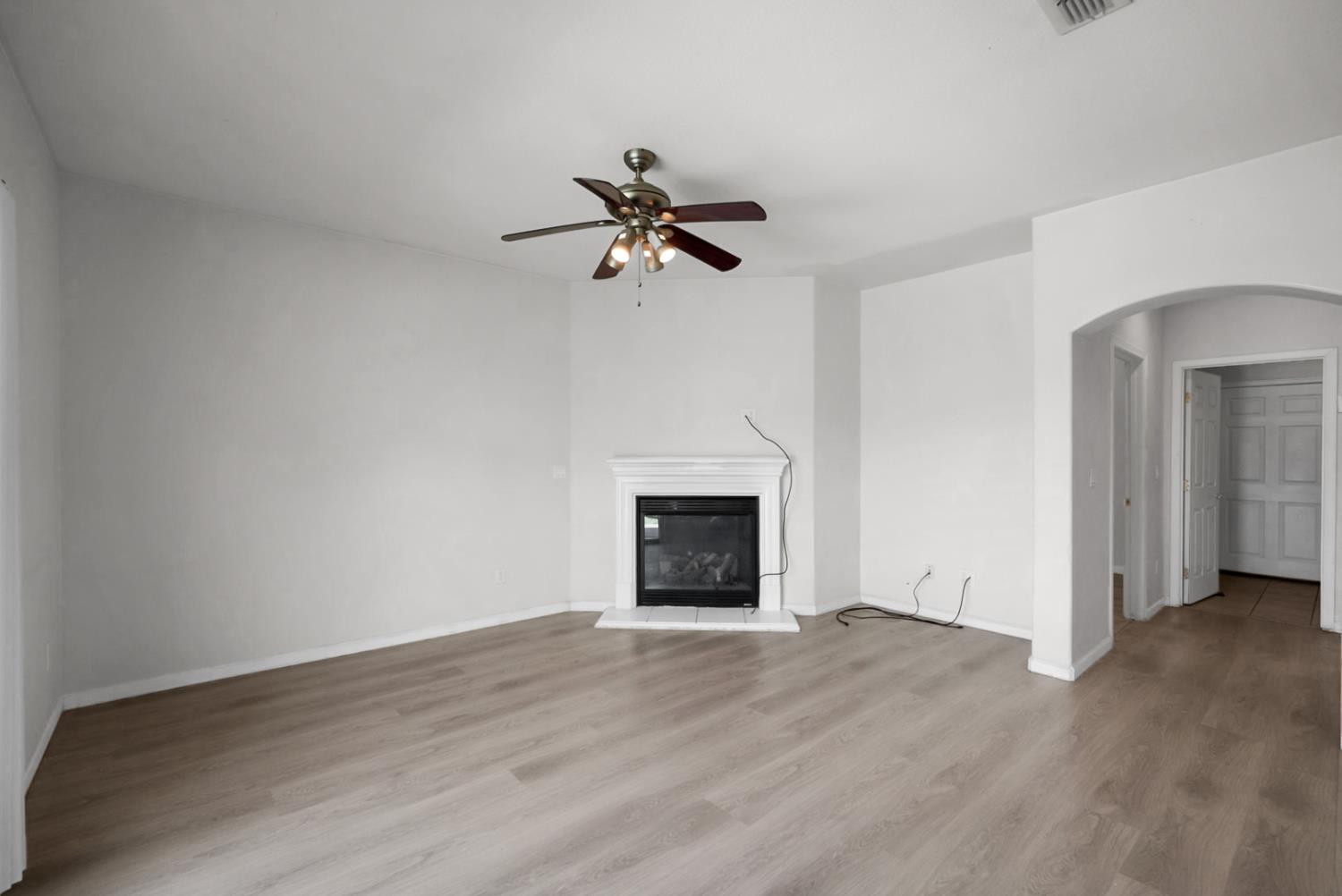 1412 Red Ribbons Lane Manteca, CA 95337 - Photo 11 of 32 an empty room with a fireplace and wooden floor