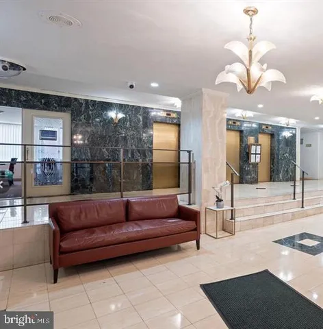 a living room with couch a dining table and a large window