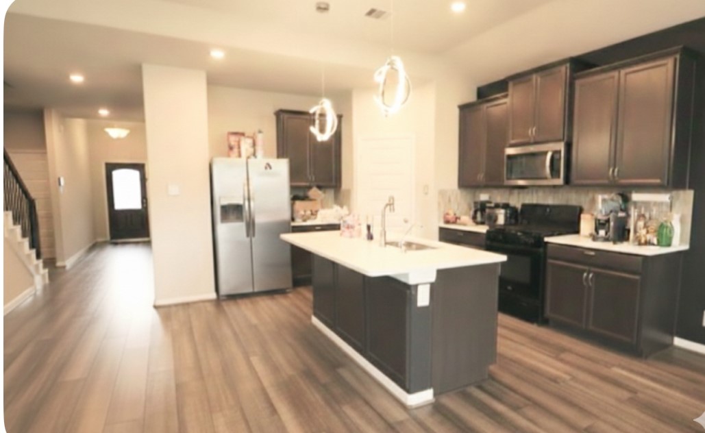 10831 Sugar Pne Lane Rosharon, TX 77583 - Photo 5 of 23 a kitchen with stainless steel appliances kitchen island granite countertop a sink stove and refrigerator
