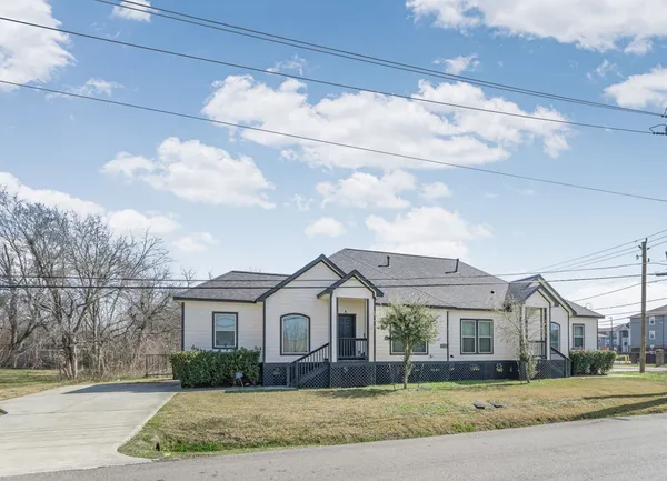 a view of a white house next to a yard