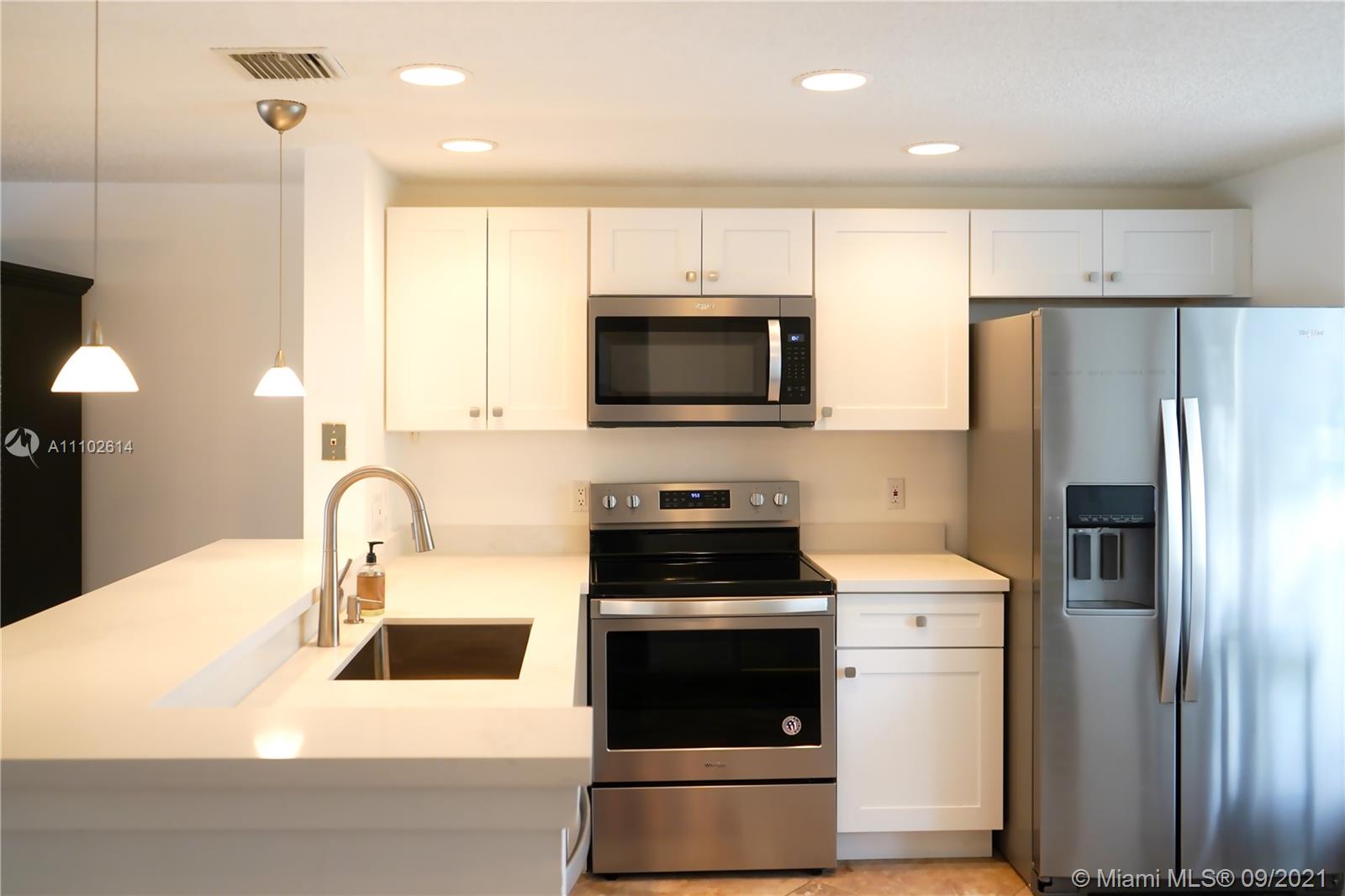 1010 Jeffery Street, Unit 1010 Boca Raton, FL 33487 - Photo 5 of 9 a kitchen with a sink a stove and refrigerator