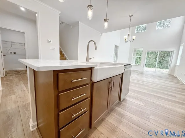 a kitchen with a sink a stove cabinets and wooden floor