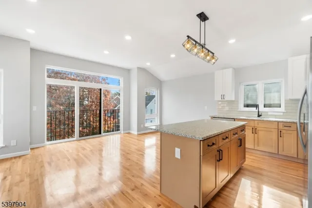 a kitchen with granite countertop a sink a counter top space and stainless steel appliances