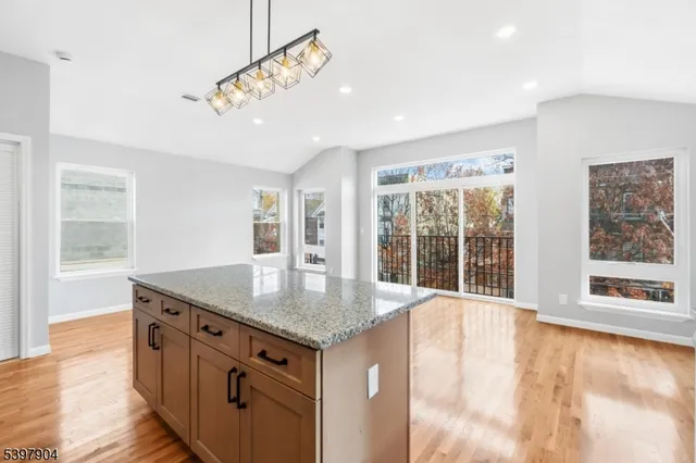 a kitchen with stainless steel appliances granite countertop a stove and a large window