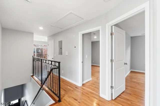 a view of a hallway with wooden floor and entryway