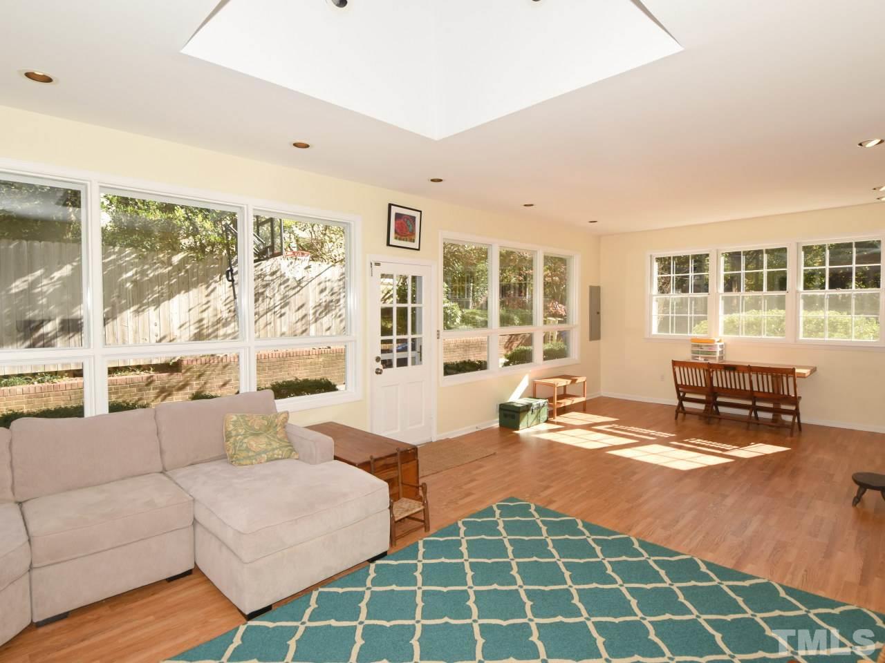 616 Macon Place Raleigh, NC 27609 - Photo 11 of 25 a living room with furniture and a floor to ceiling window