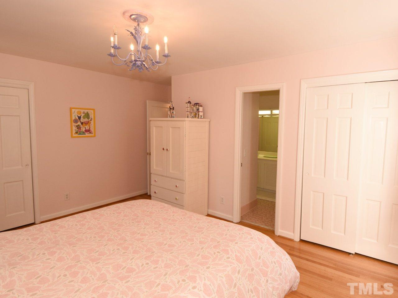 616 Macon Place Raleigh, NC 27609 - Photo 18 of 25 a spacious bedroom with a chandelier and a bathroom