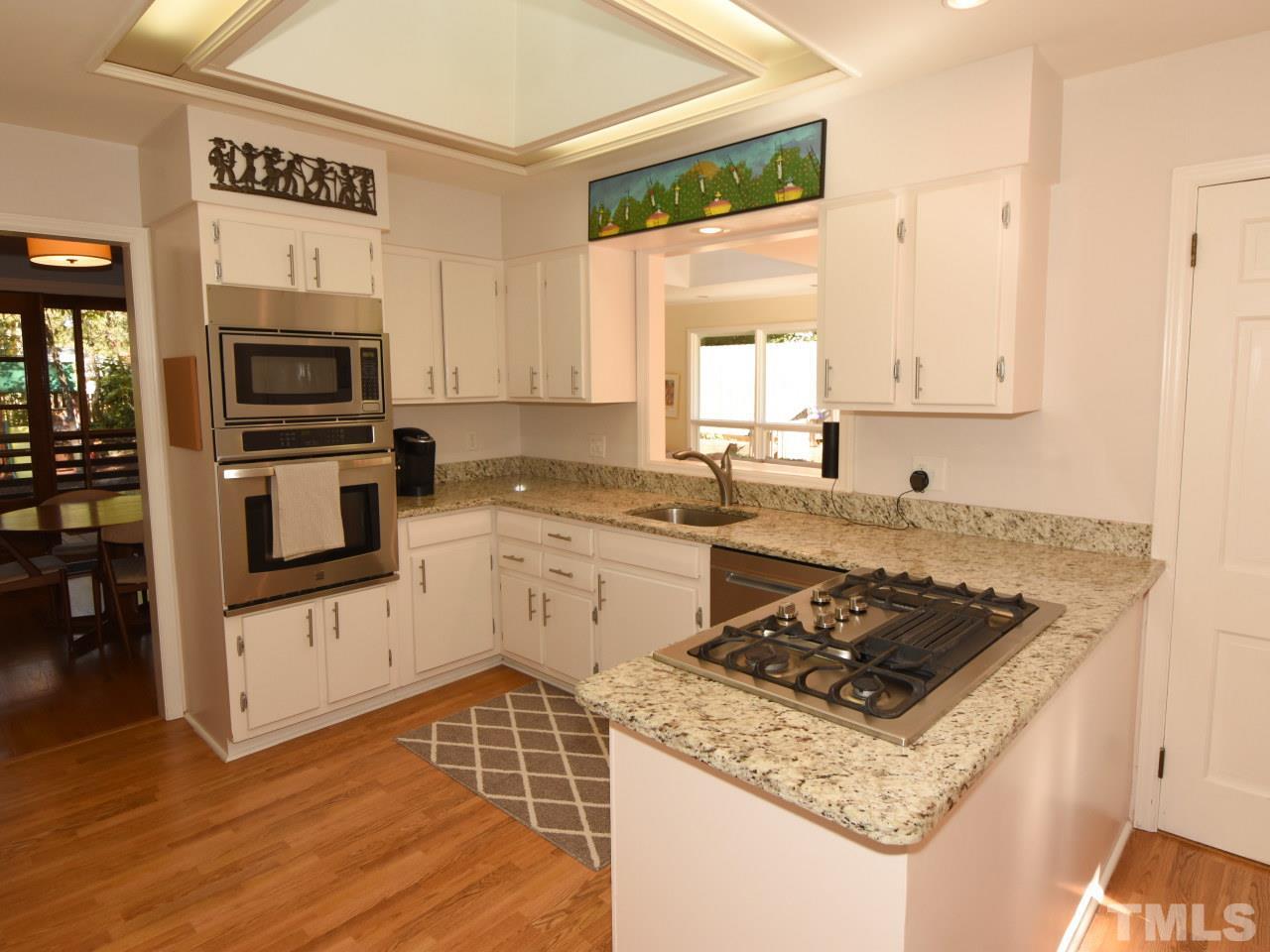 616 Macon Place Raleigh, NC 27609 - Photo 7 of 25 a kitchen with a stove a sink and a microwave