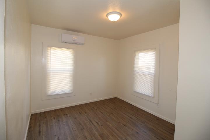 90 Magnolia Avenue Lemoore, CA 93245 - Photo 11 of 17 an empty room with wooden floor and windows