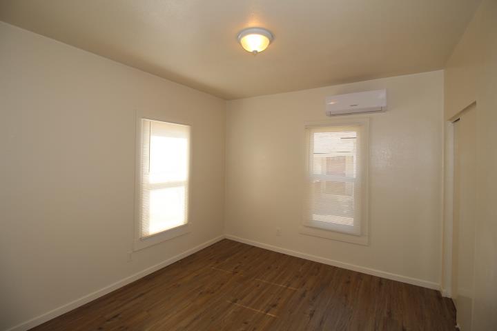 90 Magnolia Avenue Lemoore, CA 93245 - Photo 12 of 17 an empty room with wooden floor and windows