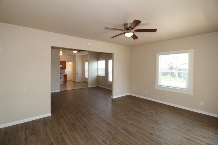 90 Magnolia Avenue Lemoore, CA 93245 - Photo 4 of 17 a view of an empty room with wooden floor and a window