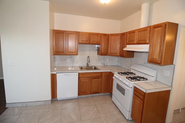 90 Magnolia Avenue Lemoore, CA 93245 - Photo 7 of 17 a kitchen with stainless steel appliances granite countertop a stove a sink and a refrigerator