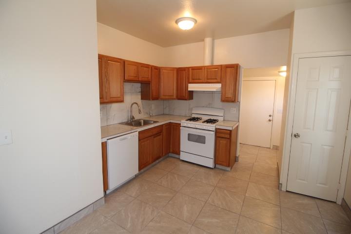 90 Magnolia Avenue Lemoore, CA 93245 - Photo 8 of 17 a kitchen with stainless steel appliances a stove a sink and a refrigerator