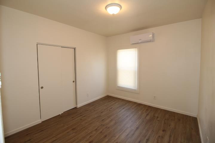 90 Magnolia Avenue Lemoore, CA 93245 - Photo 10 of 17 an empty room with wooden floor and windows