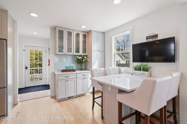 a living room with furniture a flat screen tv and kitchen view