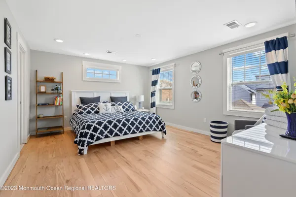 a bedroom with a bed and a table in it with wooden floor