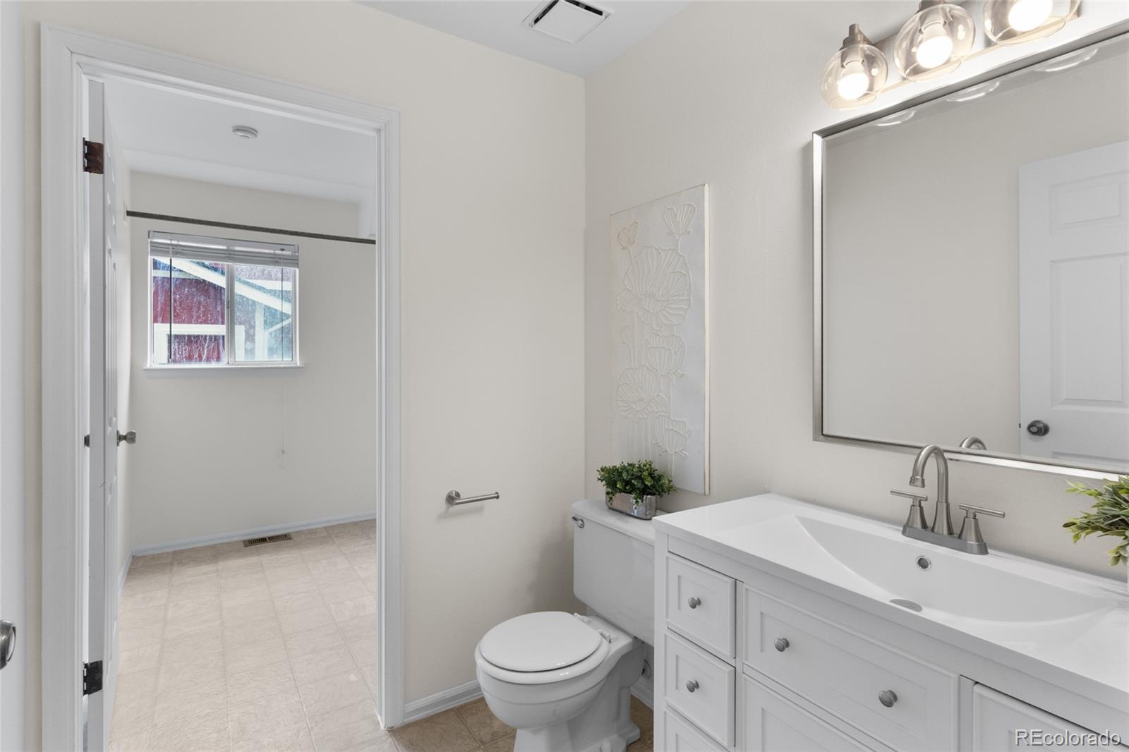 8441 Timberwood Street Highlands Ranch, CO 80126 - Photo 16 of 32 a bathroom with a toilet a sink and mirror