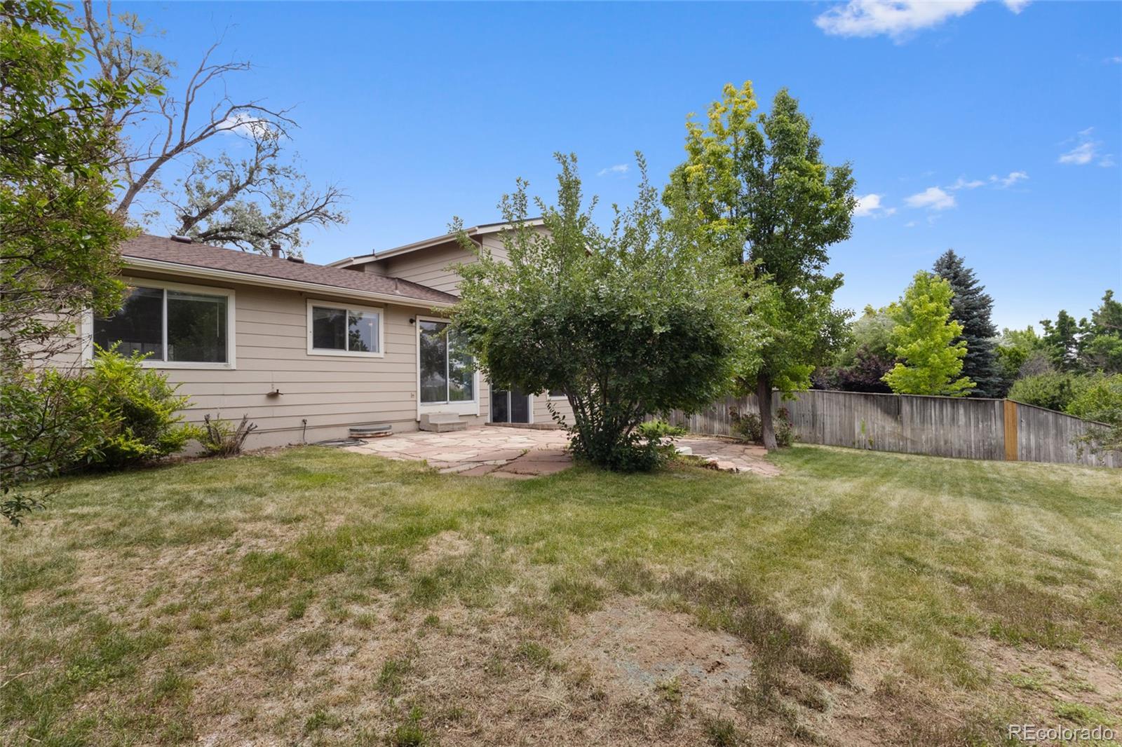 8441 Timberwood Street Highlands Ranch, CO 80126 - Photo 27 of 32 a view of a backyard with a garden and trees